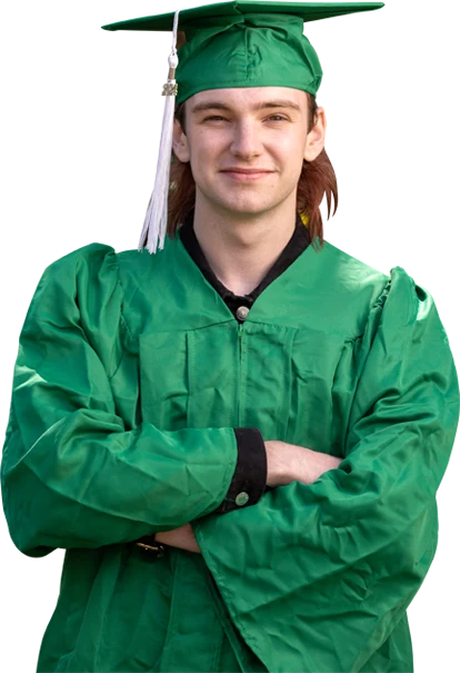 Young adult male standing in graduation cap and gown in front of wooded area