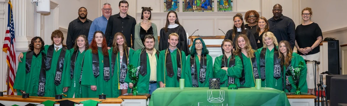 Students standing in front of sanctuary wearing their graduation gowns