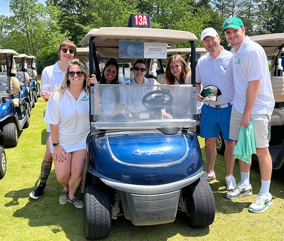 Emerald School team in a golf cart at the fundraiser